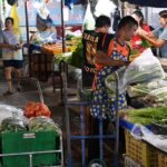 A market stall piled with fresh vegetables
