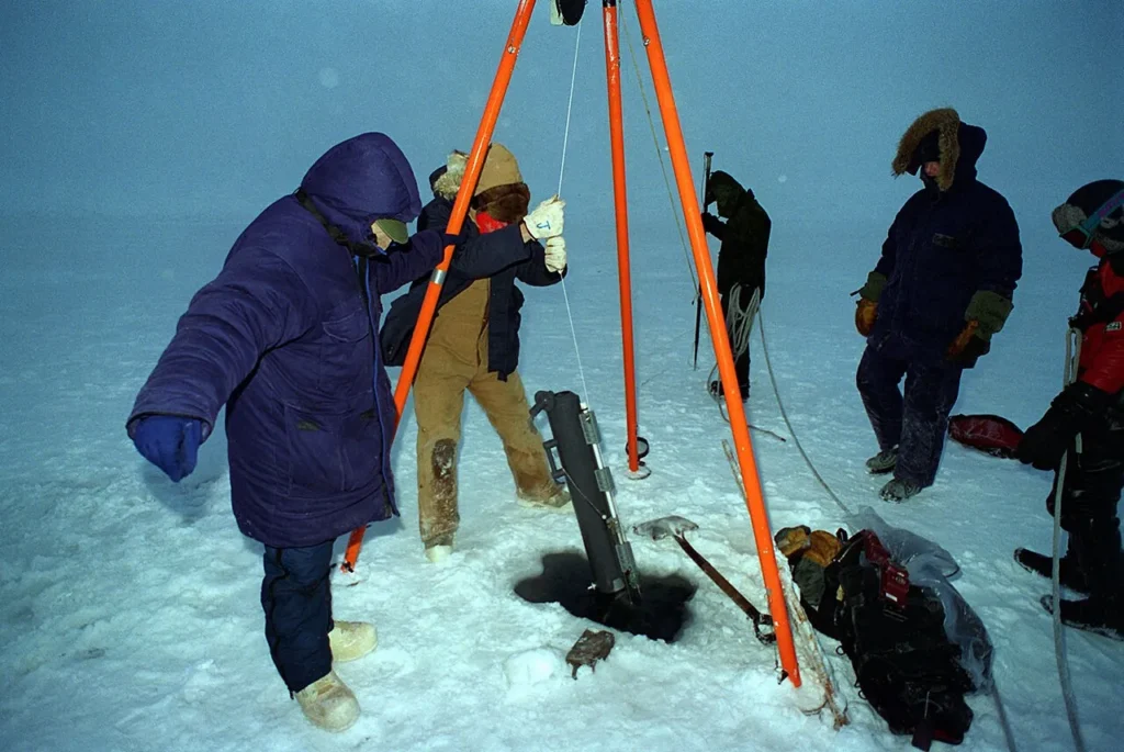 Researchers collecting a water sample with a Niskin bottle at sea